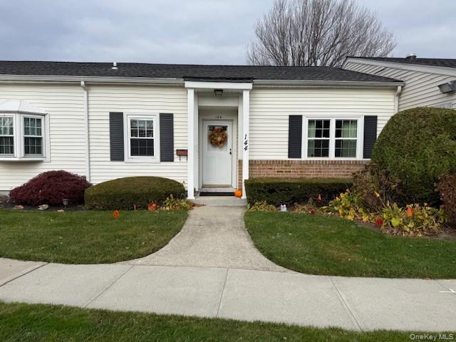 View of front of home with brick siding and a front lawn
