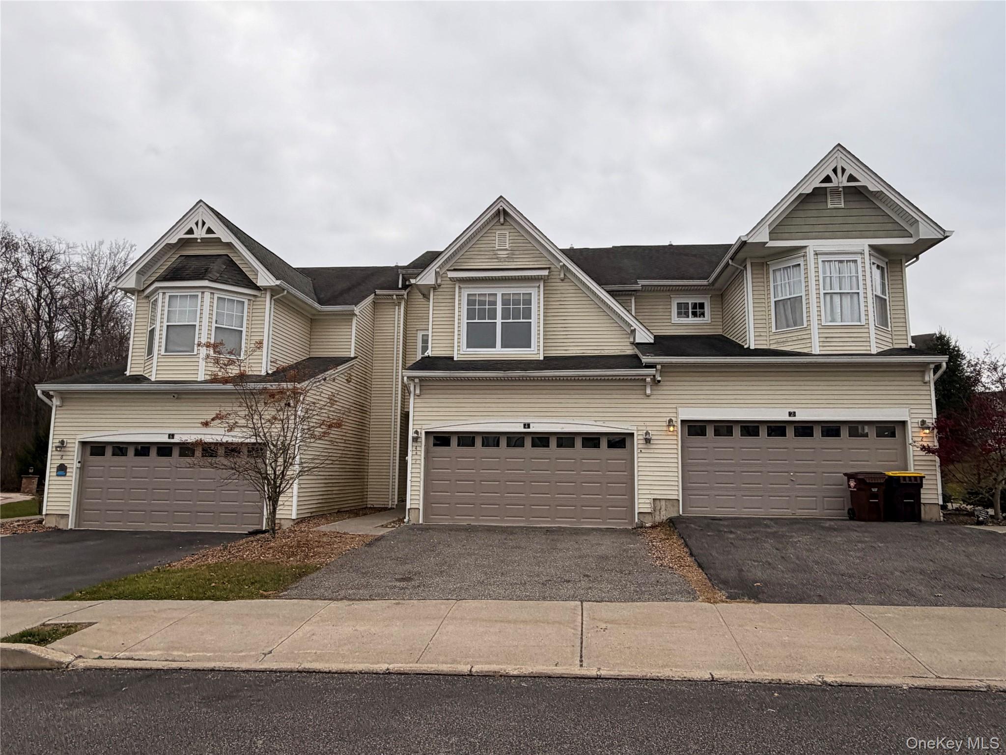 View of front of home featuring a garage and asphalt driveway