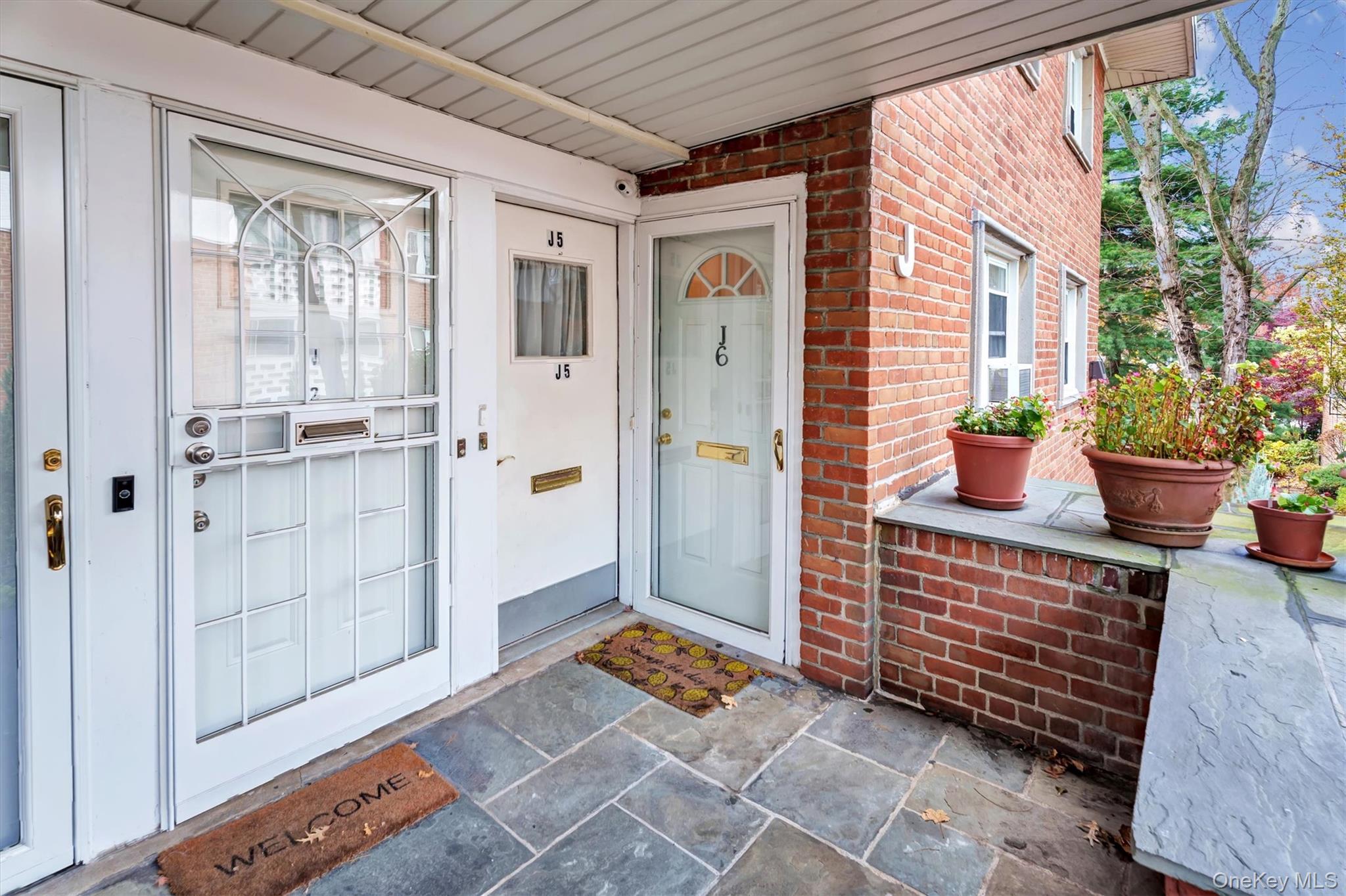 View of exterior entry featuring brick siding and covered porch