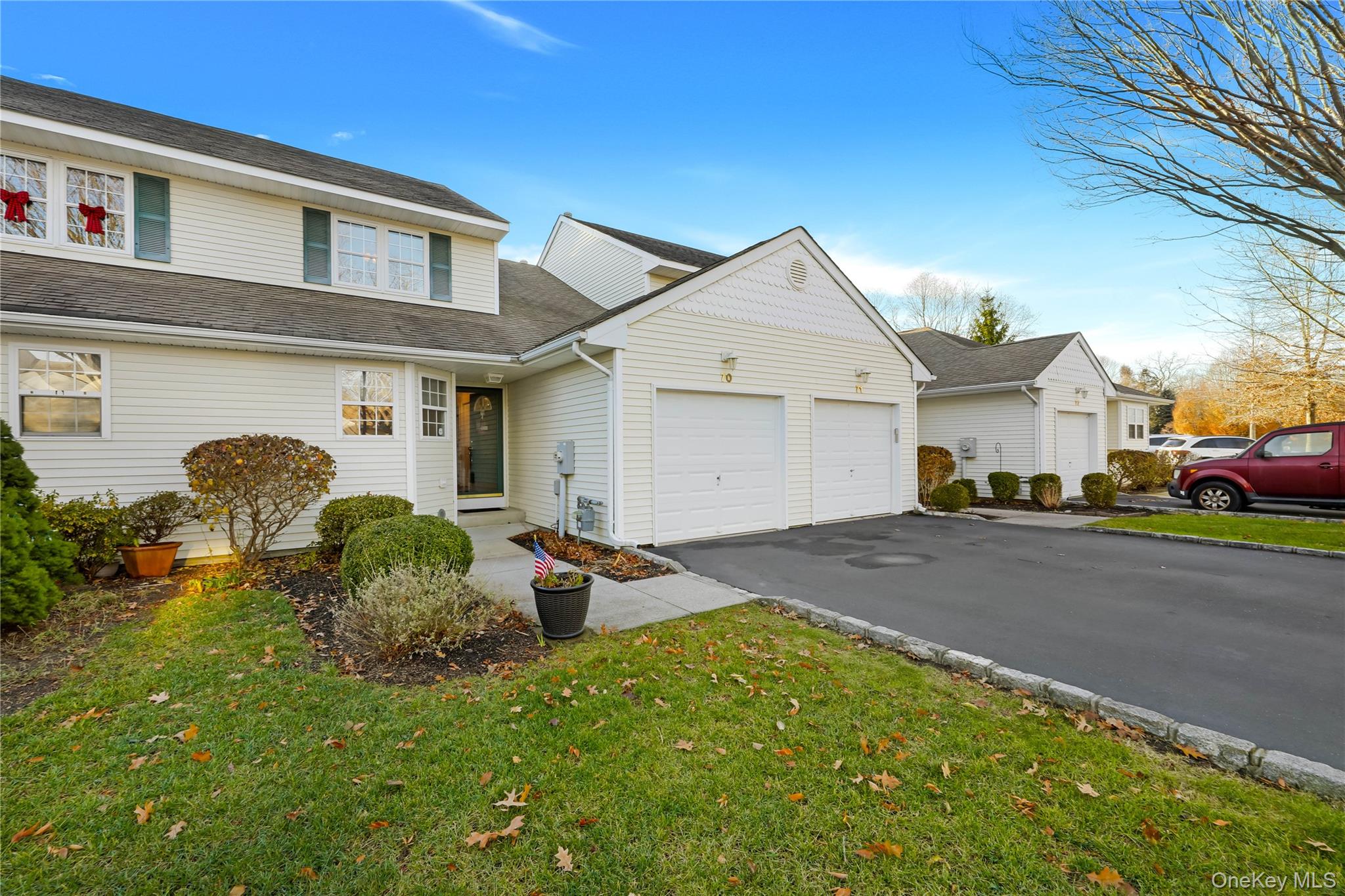 Traditional home with driveway, roof with shingles, a garage, and a front yard