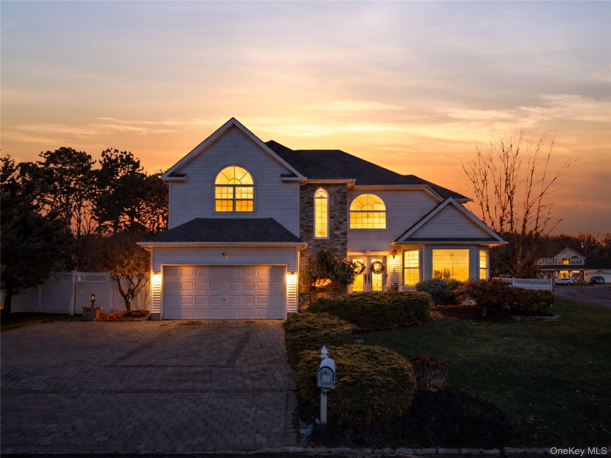 Traditional-style house featuring decorative driveway and an attached garage