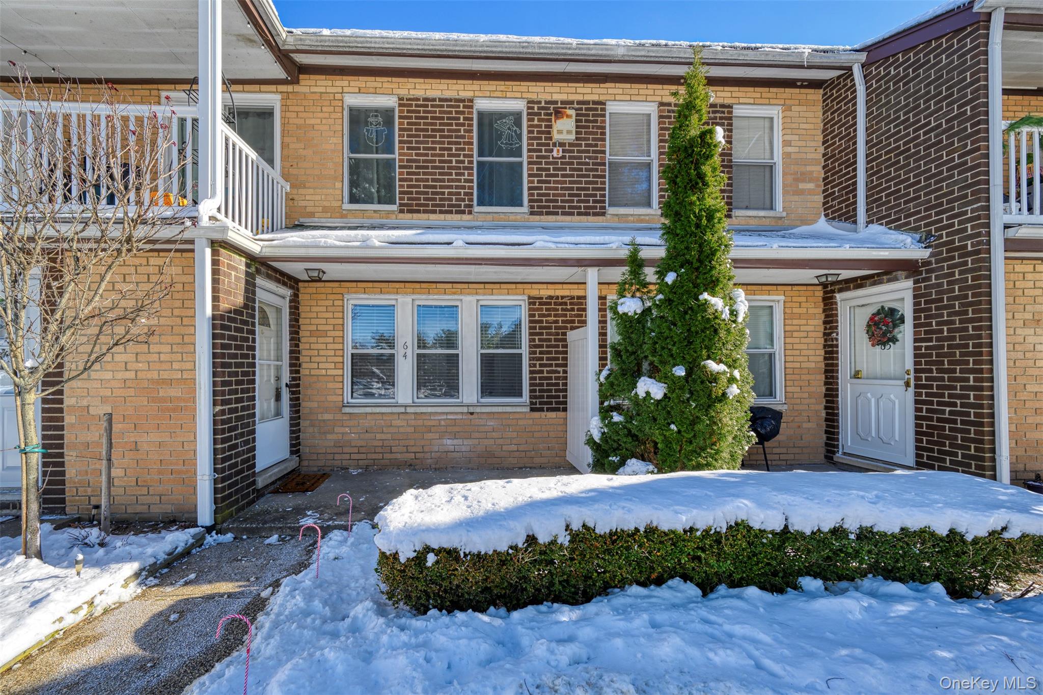 View of front of house featuring brick siding and a balcony