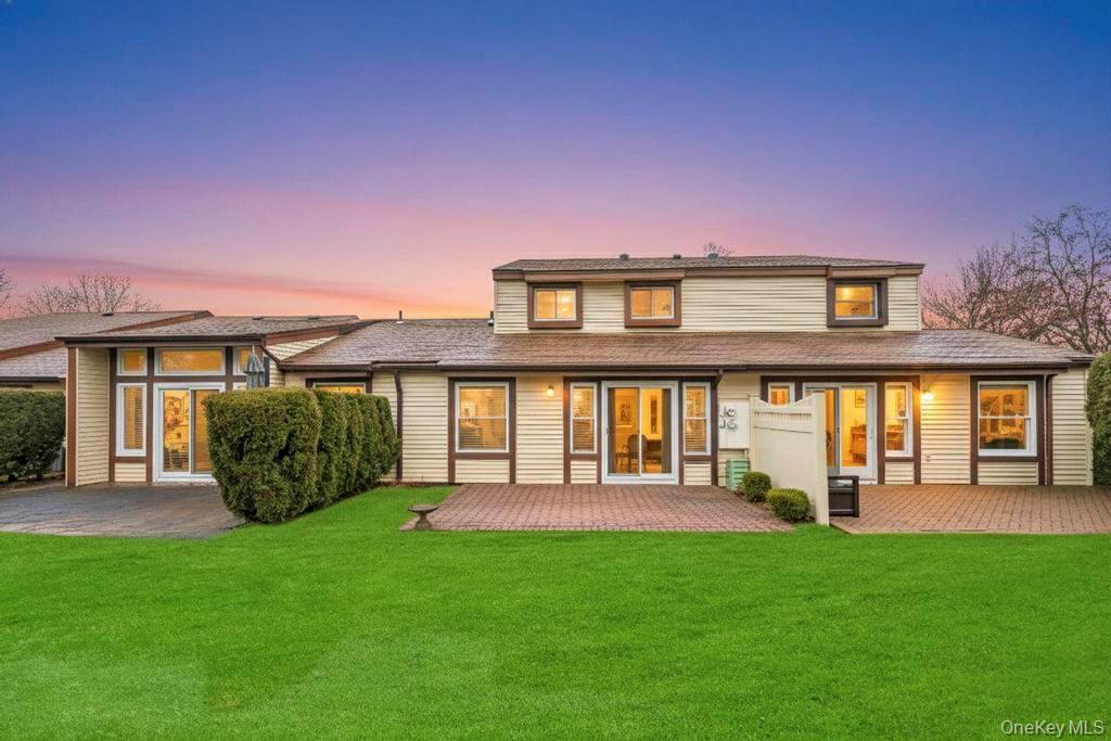 Back of house featuring a lawn and a deck