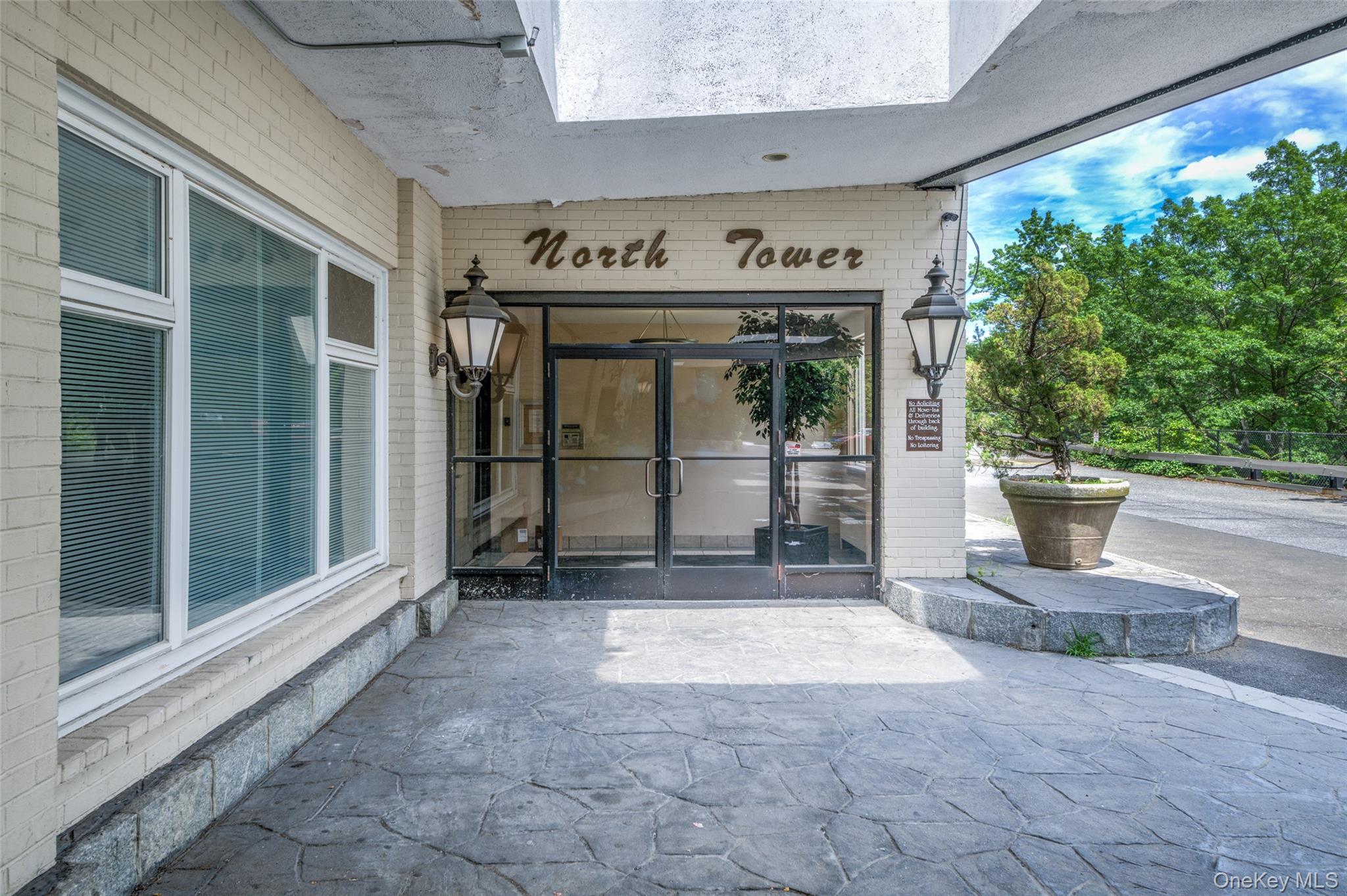 Entrance to property featuring brick siding and a patio area