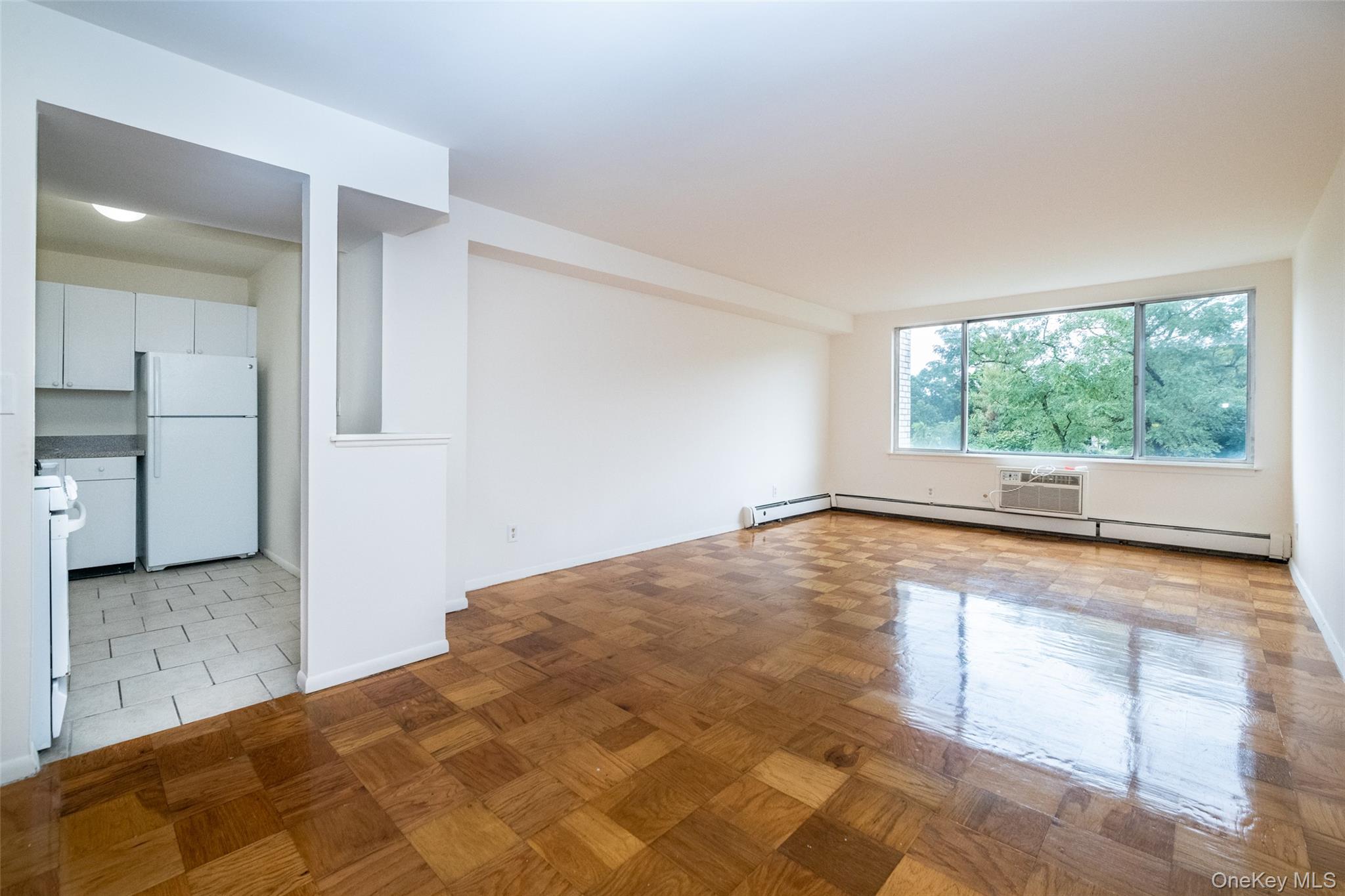 Empty room with a wall mounted air conditioner and a baseboard heating unit