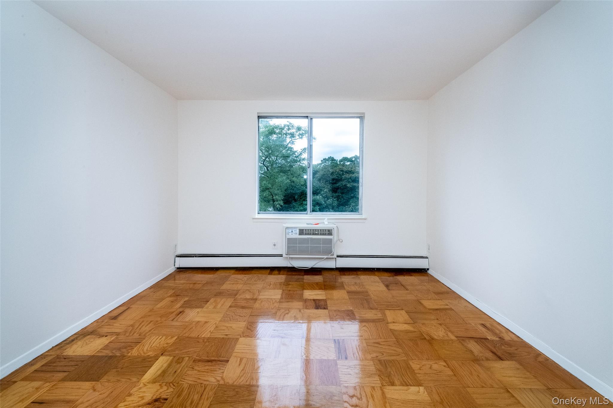 Unfurnished room featuring baseboards and a baseboard radiator