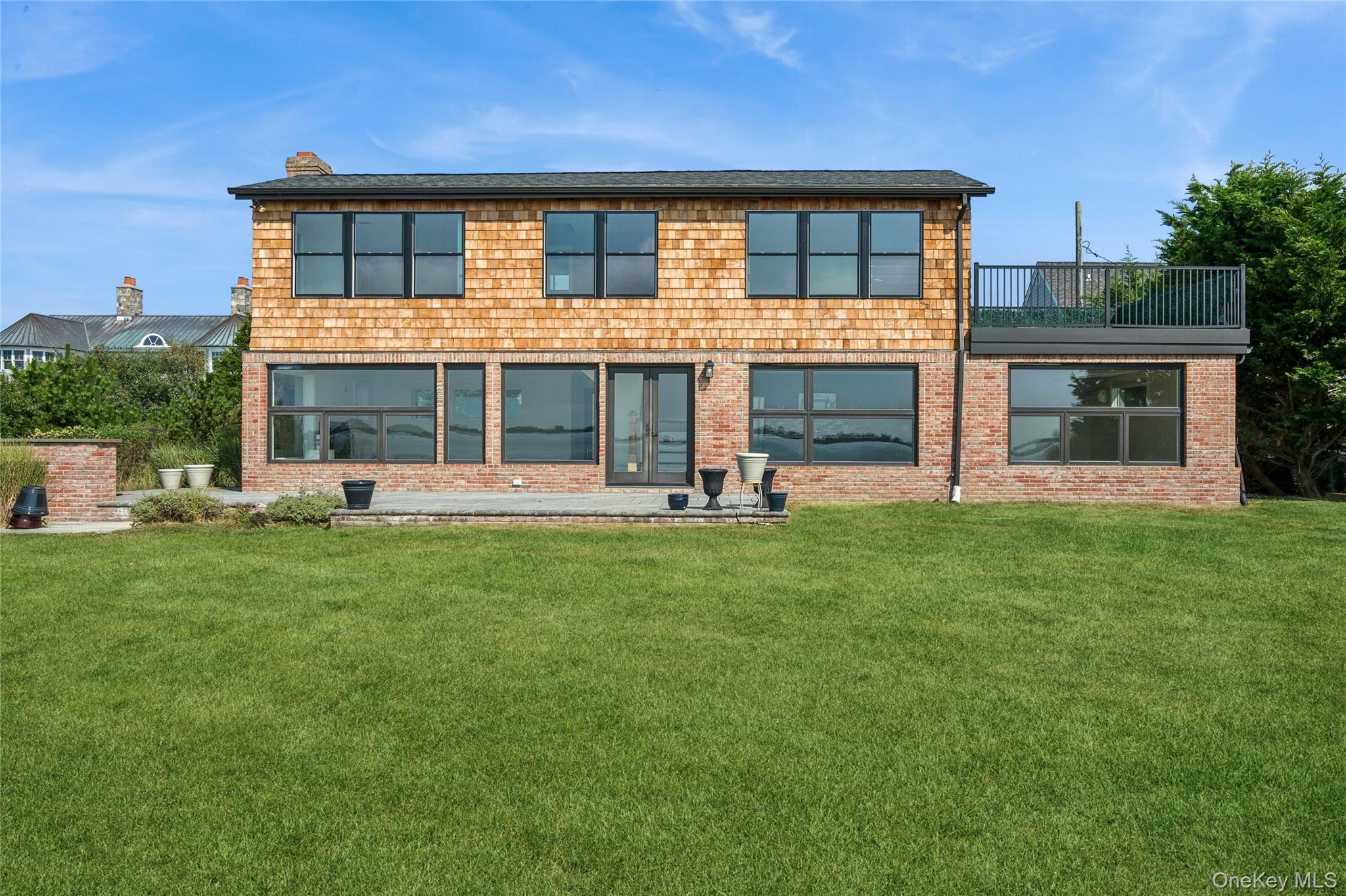 Rear view of house with a lawn and brick siding