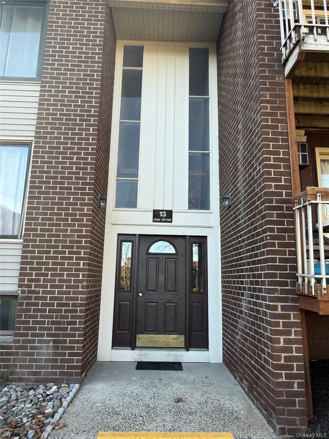 Doorway to Building 13 with brick siding, stairs go up to unit 138