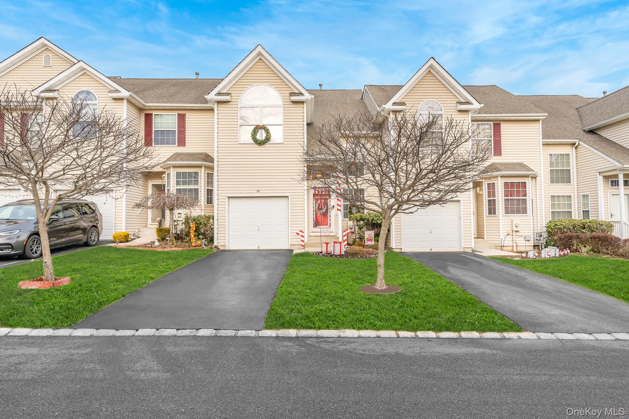 Traditional home with driveway, a shingled roof, a front lawn, and a garage