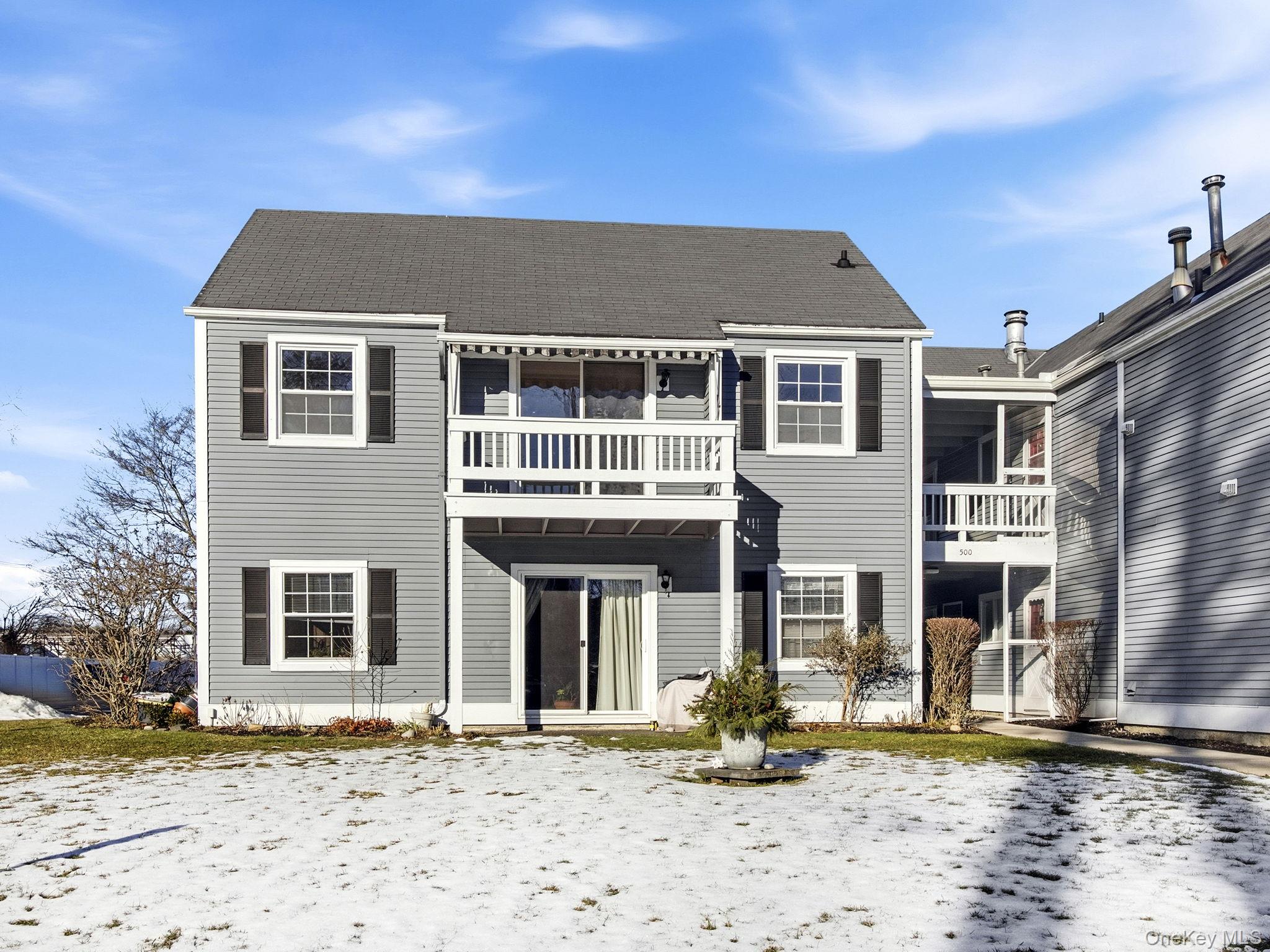 Snow covered house with a balcony and a patio