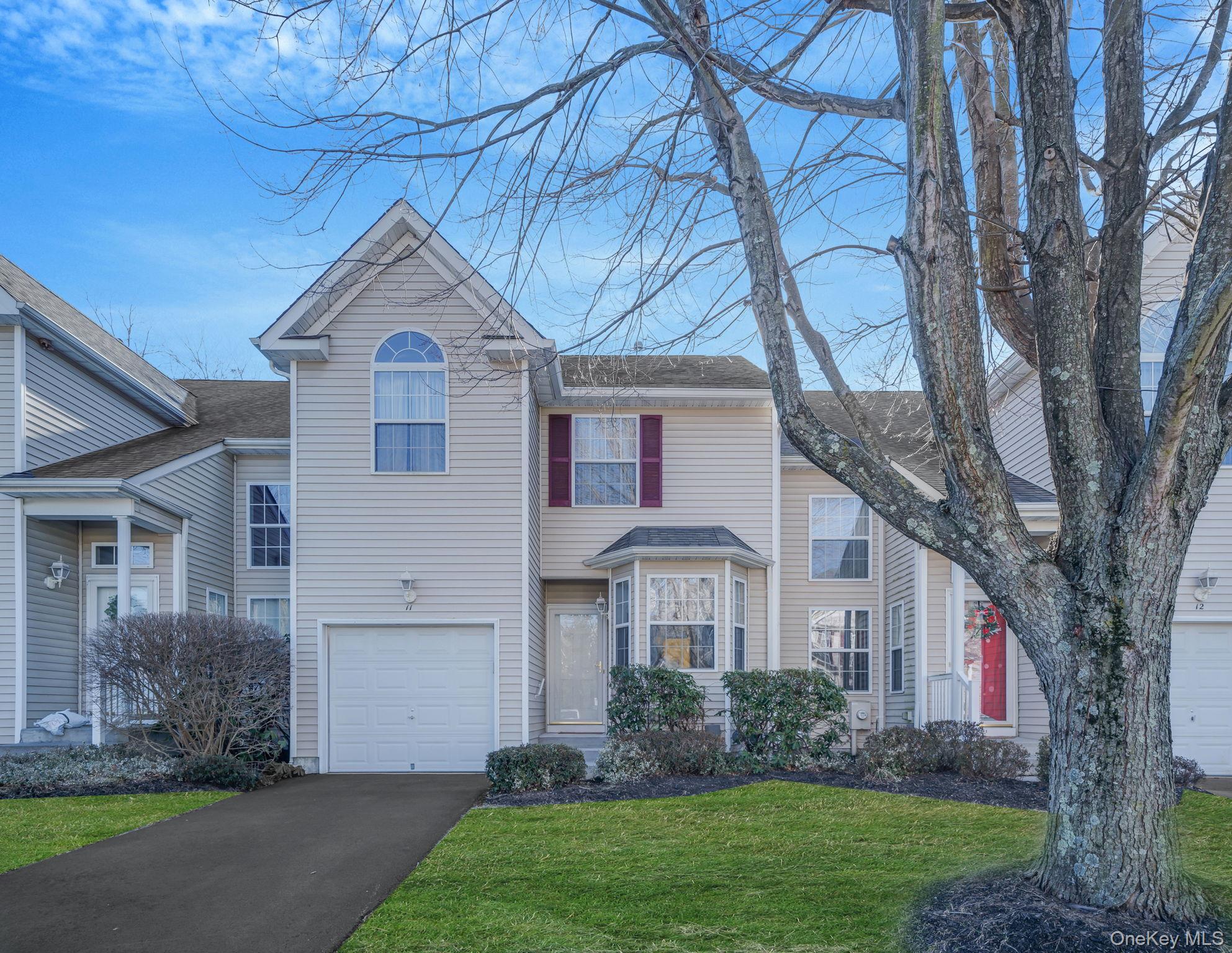 Front of unit with driveway and 1 car garage.