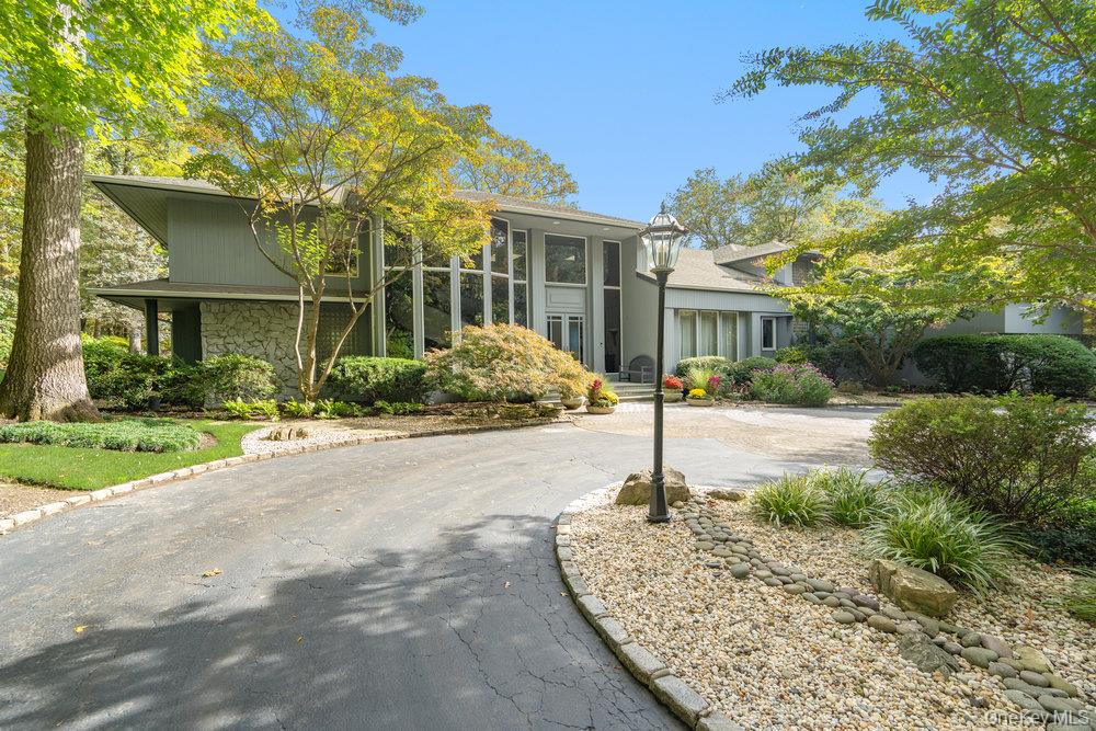 View of front of property featuring stone siding and circular driveway