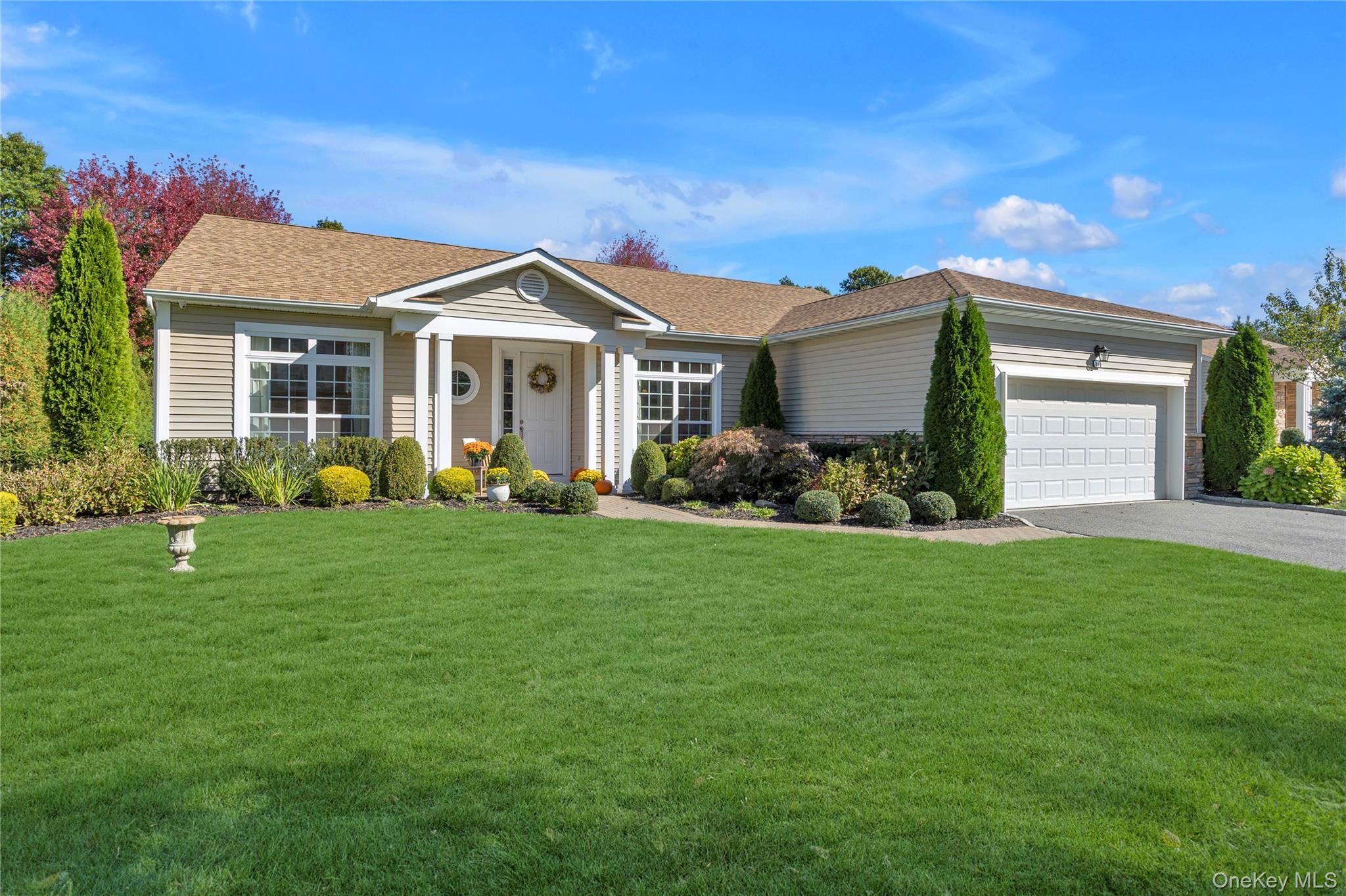 Ranch-style house featuring a front lawn, asphalt driveway, an attached 2 car garage,