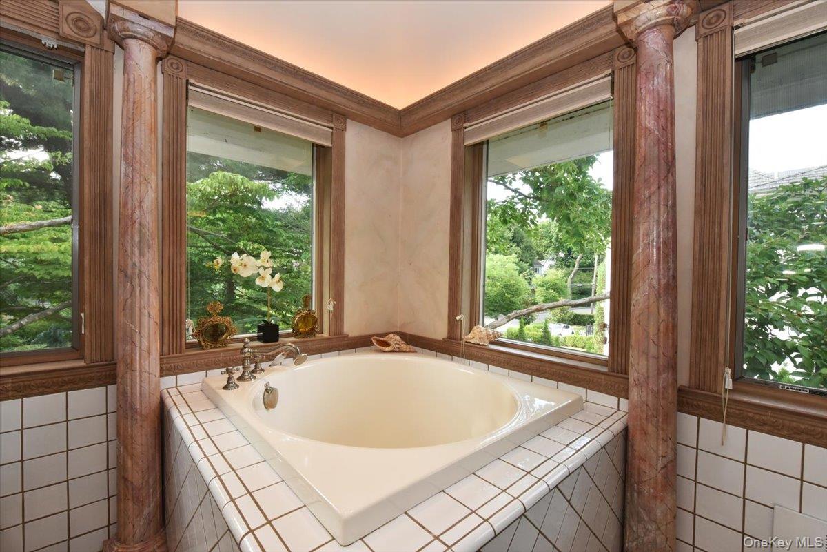 Full bathroom with a bath and a healthy amount of sunlight