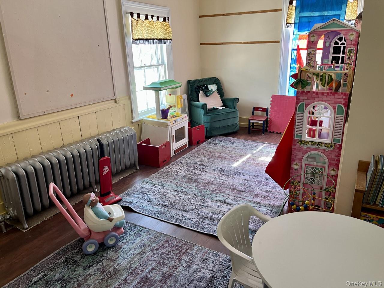 Sitting room with radiator heating unit and wood finished floors