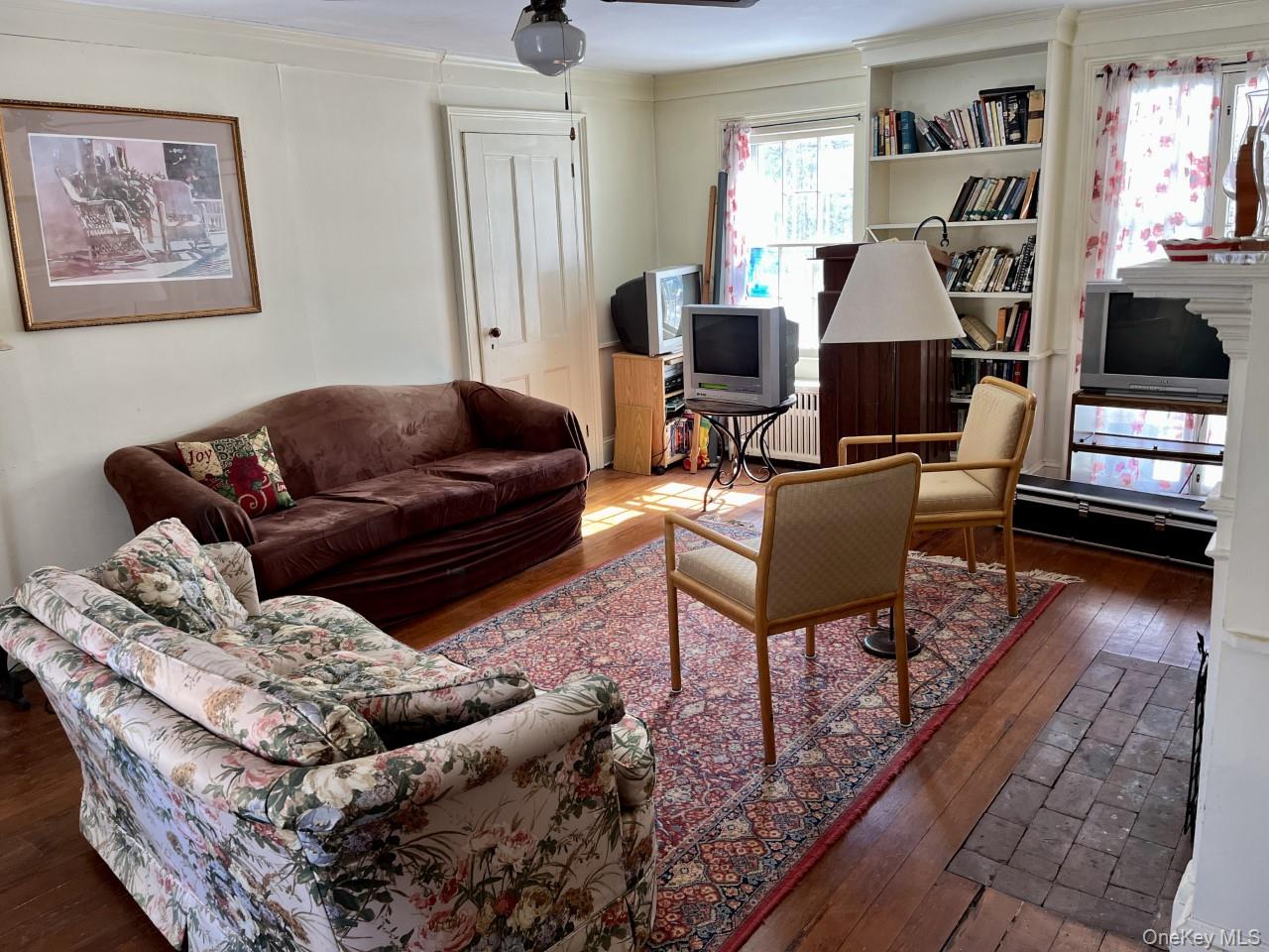 Living room with wood-type flooring and ceiling fan