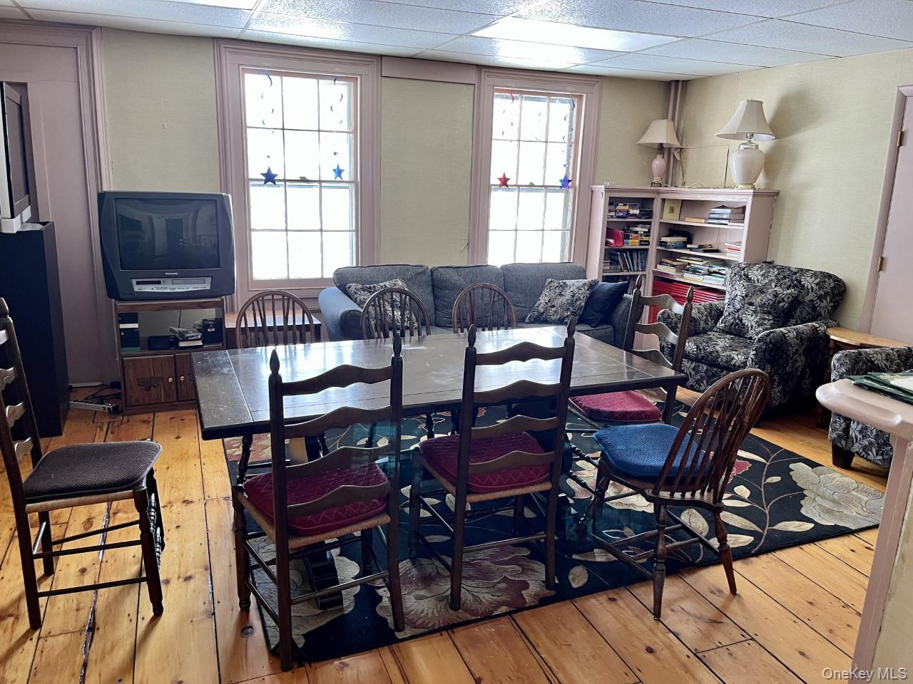 Dining area featuring hardwood / wood-style flooring and a paneled ceiling