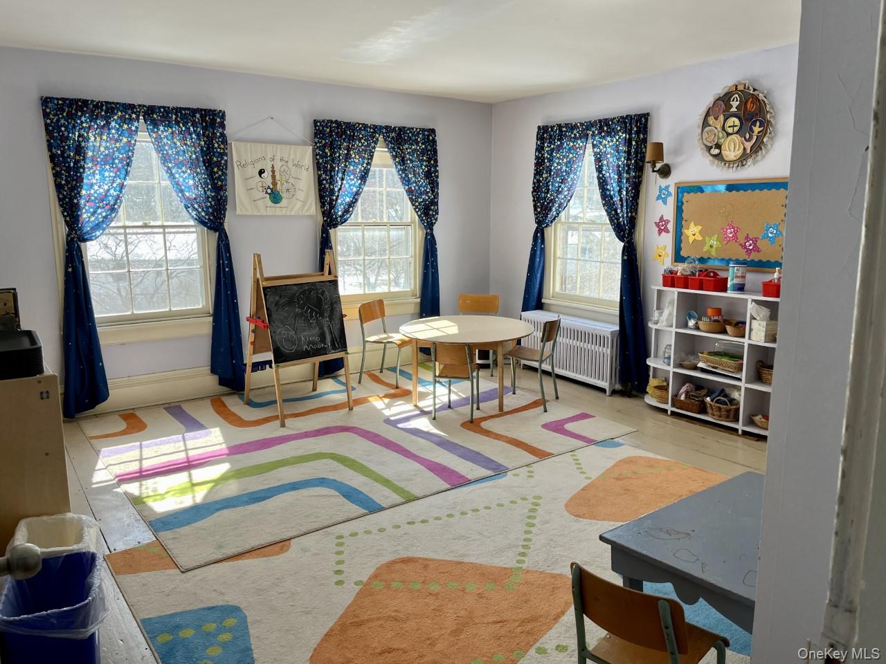 Playroom with radiator heating unit and wood finished floors