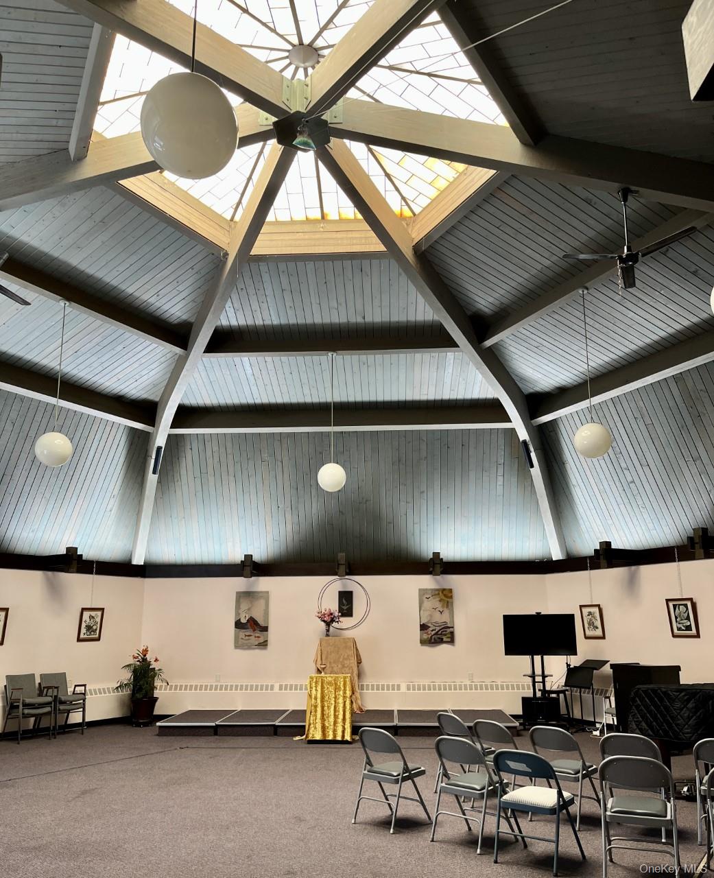 room featuring high vaulted ceiling and beamed ceiling