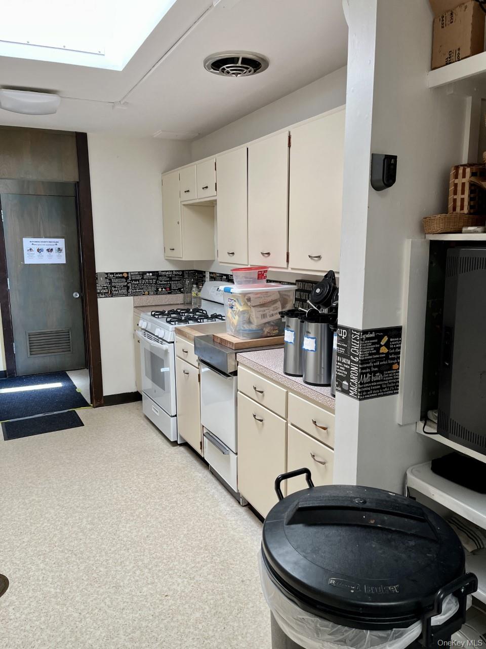 Kitchen featuring gas range gas stove and white cabinets