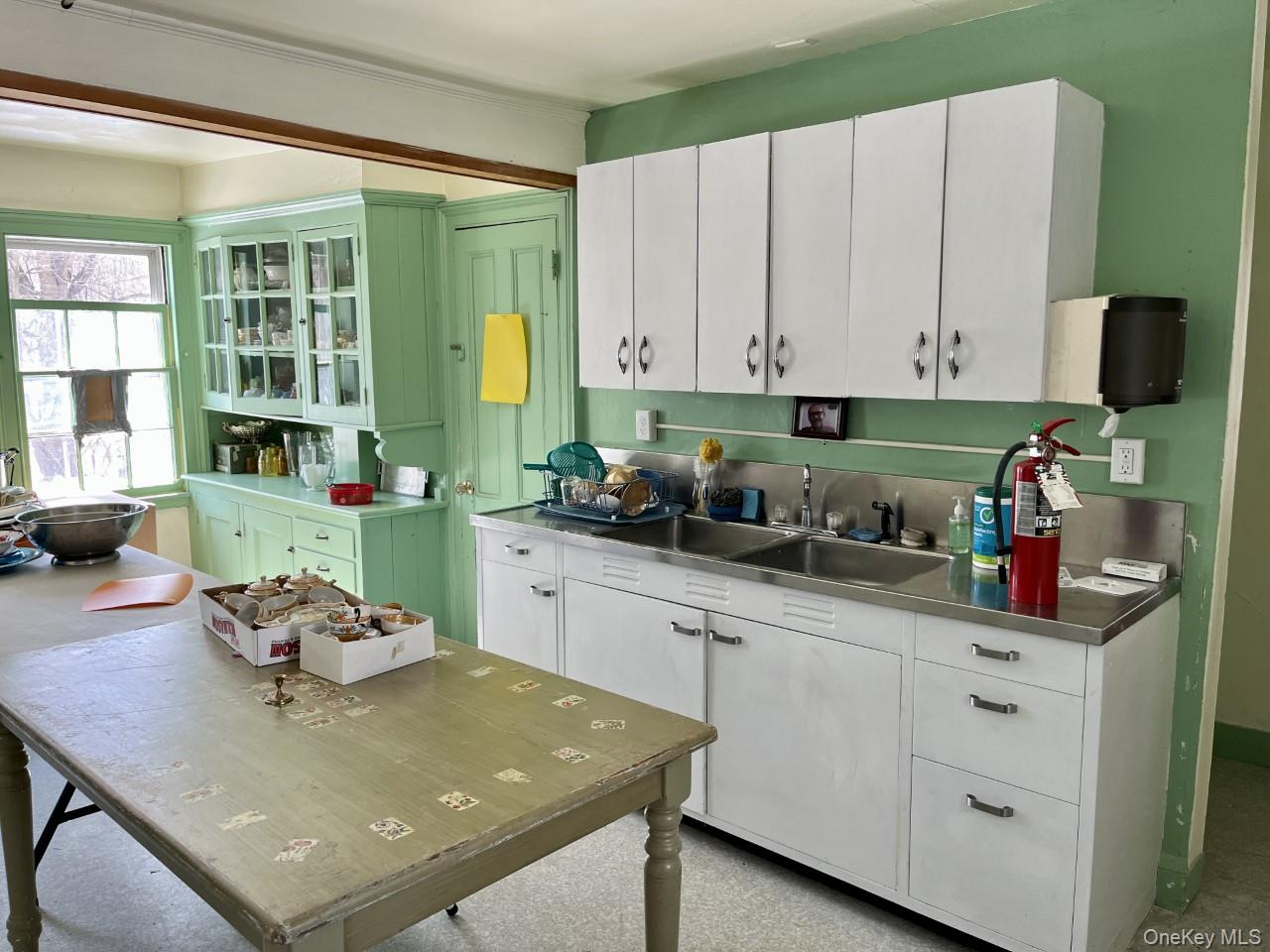 Kitchen with a sink, white cabinetry, and a center island