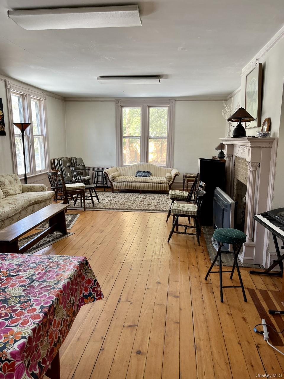 Living room with hardwood / wood-style flooring, a fireplace, and crown molding