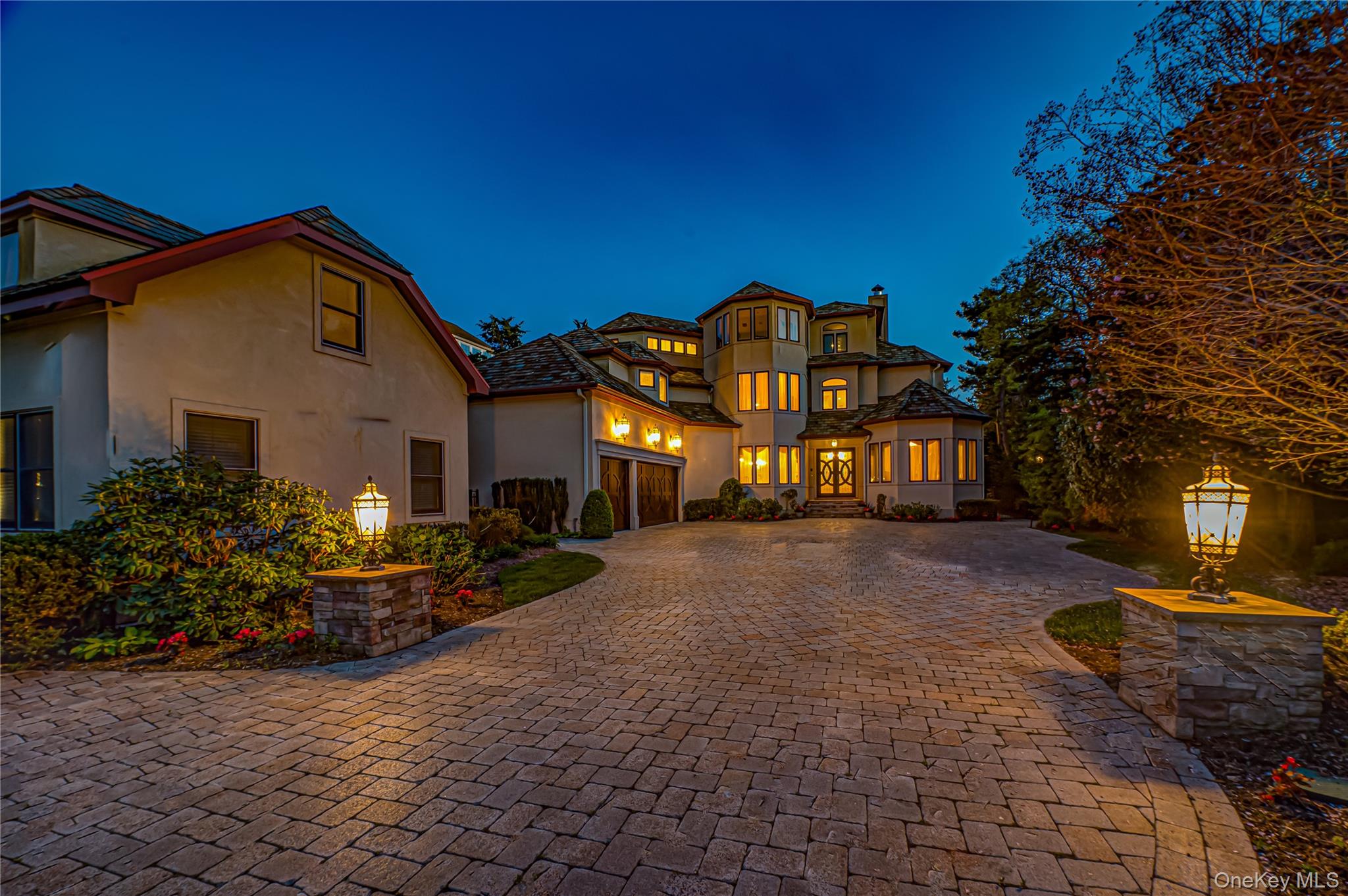 Mediterranean / spanish-style home featuring curved driveway, stucco siding, and a chimney