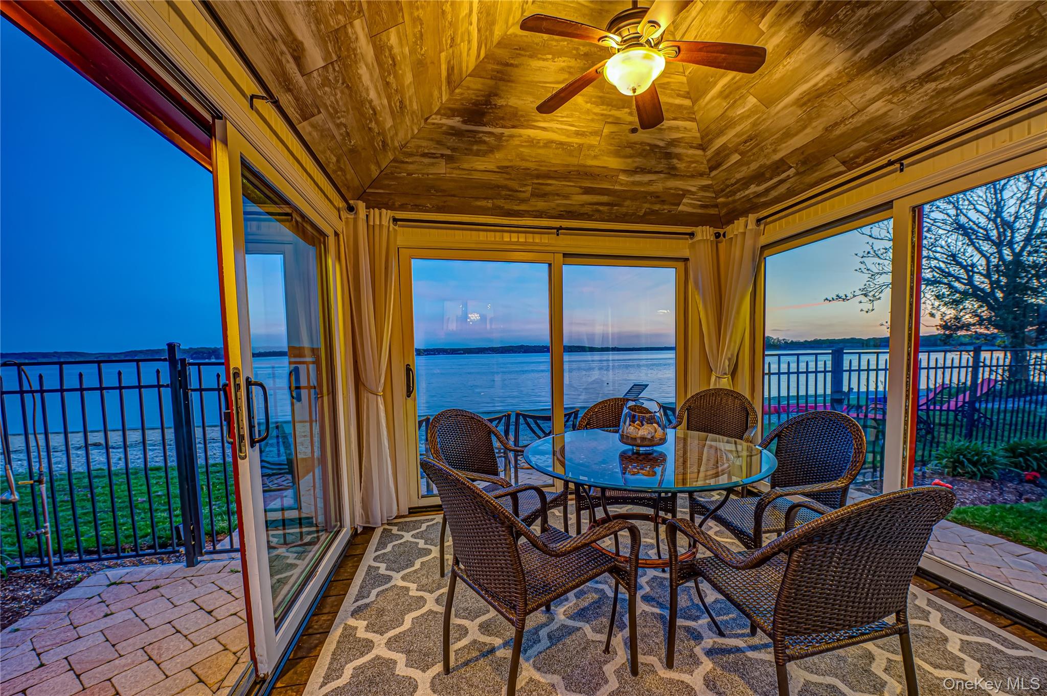 Sunroom / solarium with a water view, lofted ceiling, and wooden ceiling