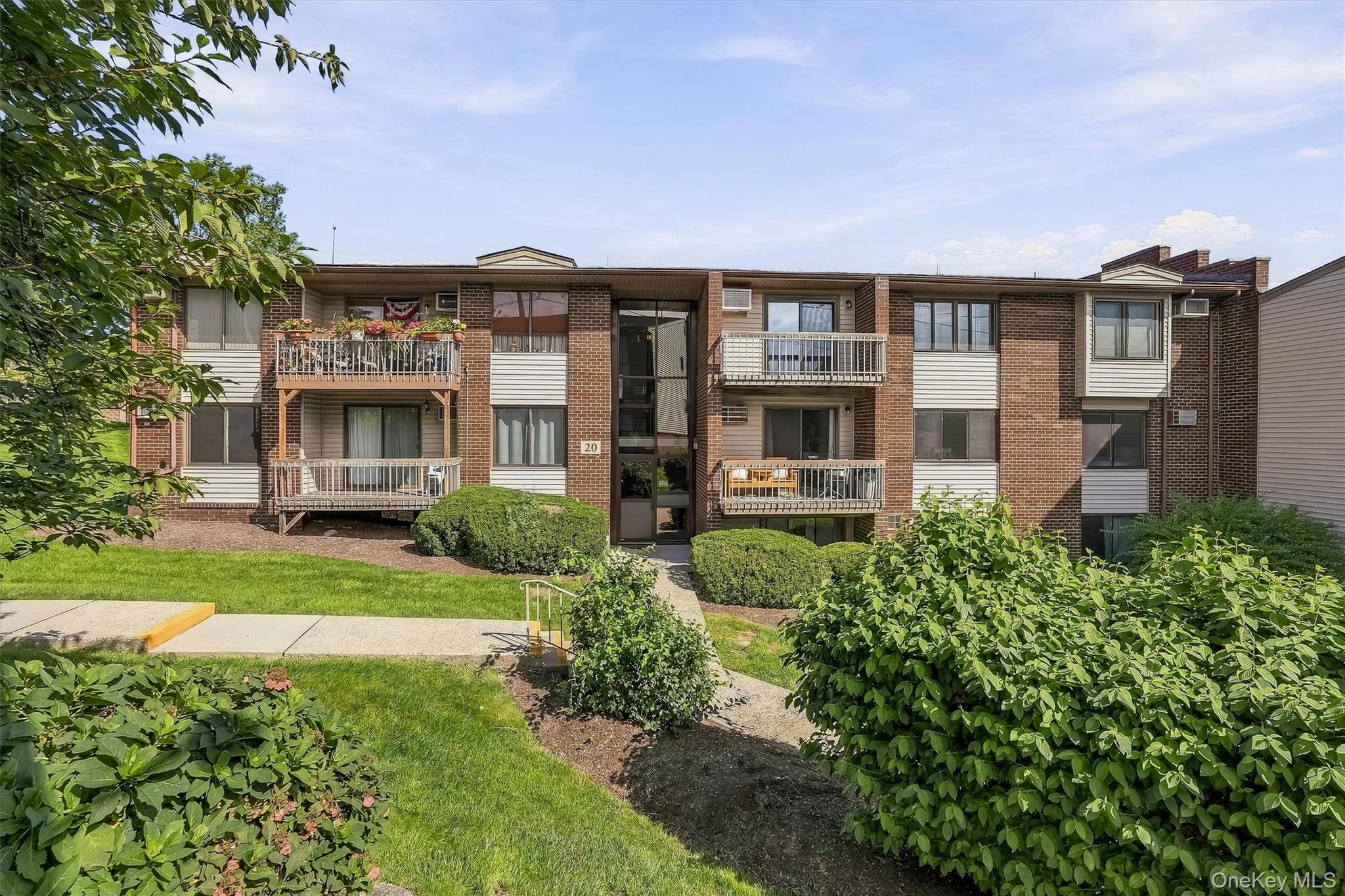 Front of building surrounded by lush landscaping.