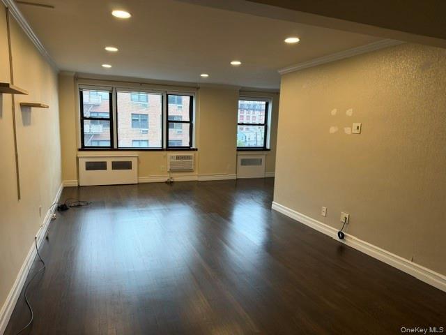 Recessed lighting, crown molding, wood-finish flooring, multiple windows, and a built-in air conditioning unit