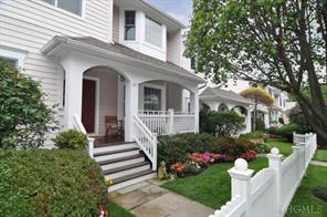 Welcome to 43 Livingston Avenue with white picket fence and covered rocking chair front porch.